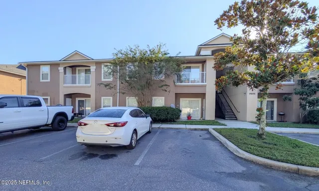 a front view of a house with yard and parking