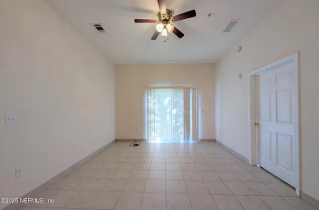 a view of an empty room with a ceiling fan