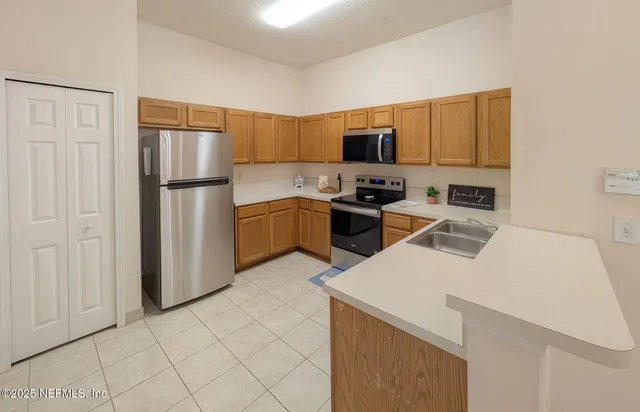a kitchen with stainless steel appliances granite countertop a refrigerator stove top oven a sink and dishwasher