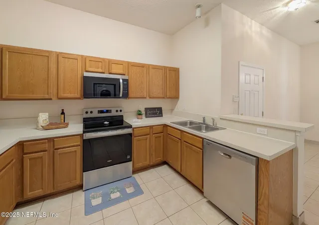 a kitchen with stainless steel appliances granite countertop a sink dishwasher stove and microwave
