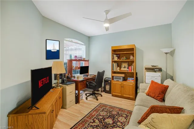 a living room with furniture a piano and a bookshelf