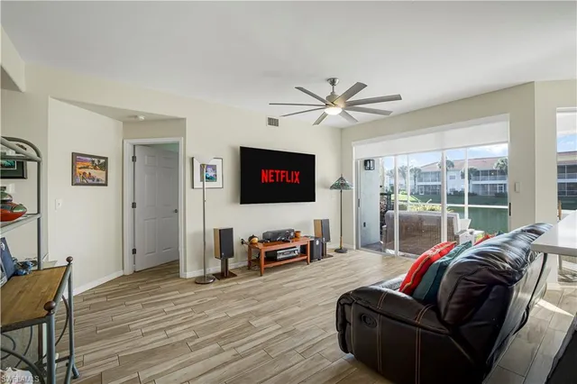 a living room with furniture a flat screen tv and a large window