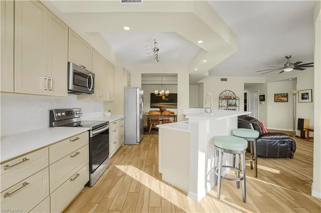 a living room with furniture a fireplace and a open kitchen