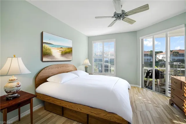 a bedroom with a bed a chandelier and next to a window
