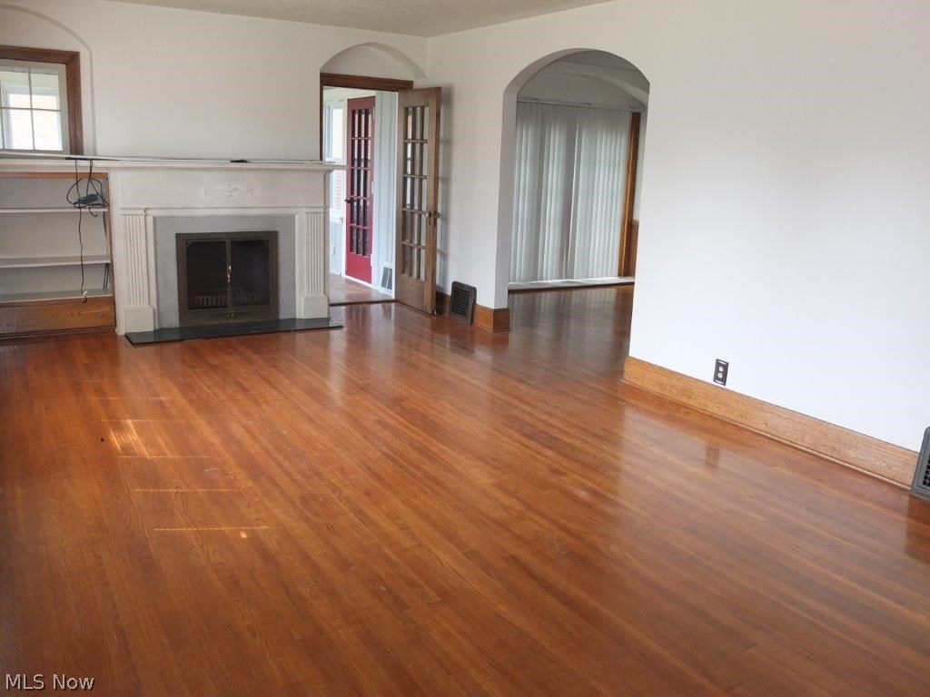 353 Raff Road Northwest Canton, OH 44708 - Photo 2 of 18 Living room has hardwood flooring, arched doorways and a fireplace.