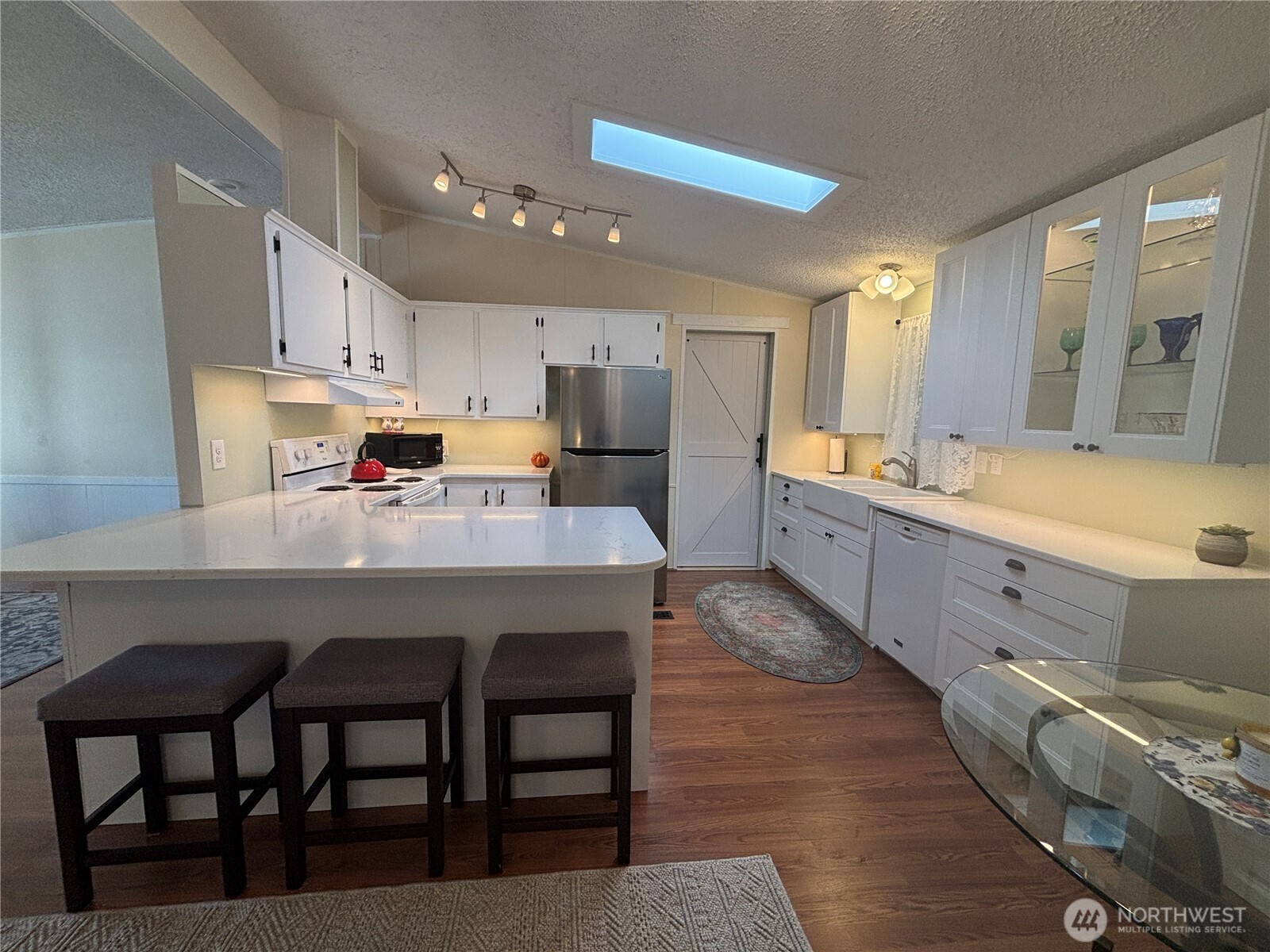930 Trosper Road Southwest, Unit 130 Tumwater, WA 98512 - Photo 12 of 14 a kitchen with stainless steel appliances kitchen island granite countertop a sink a stove a dining table and chairs