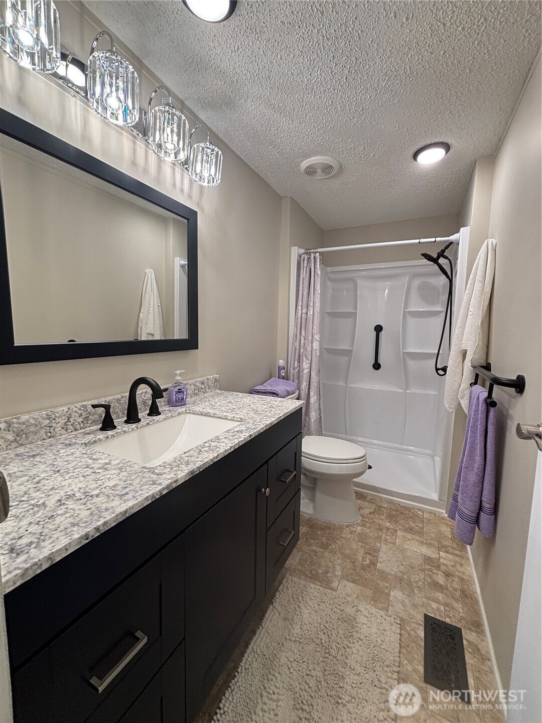 930 Trosper Road Southwest, Unit 130 Tumwater, WA 98512 - Photo 6 of 14 a bathroom with a granite countertop sink a toilet and a mirror