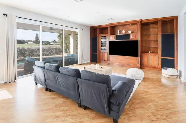 a kitchen with stainless steel appliances granite countertop a refrigerator a sink a stove and a sink with wooden cabinets