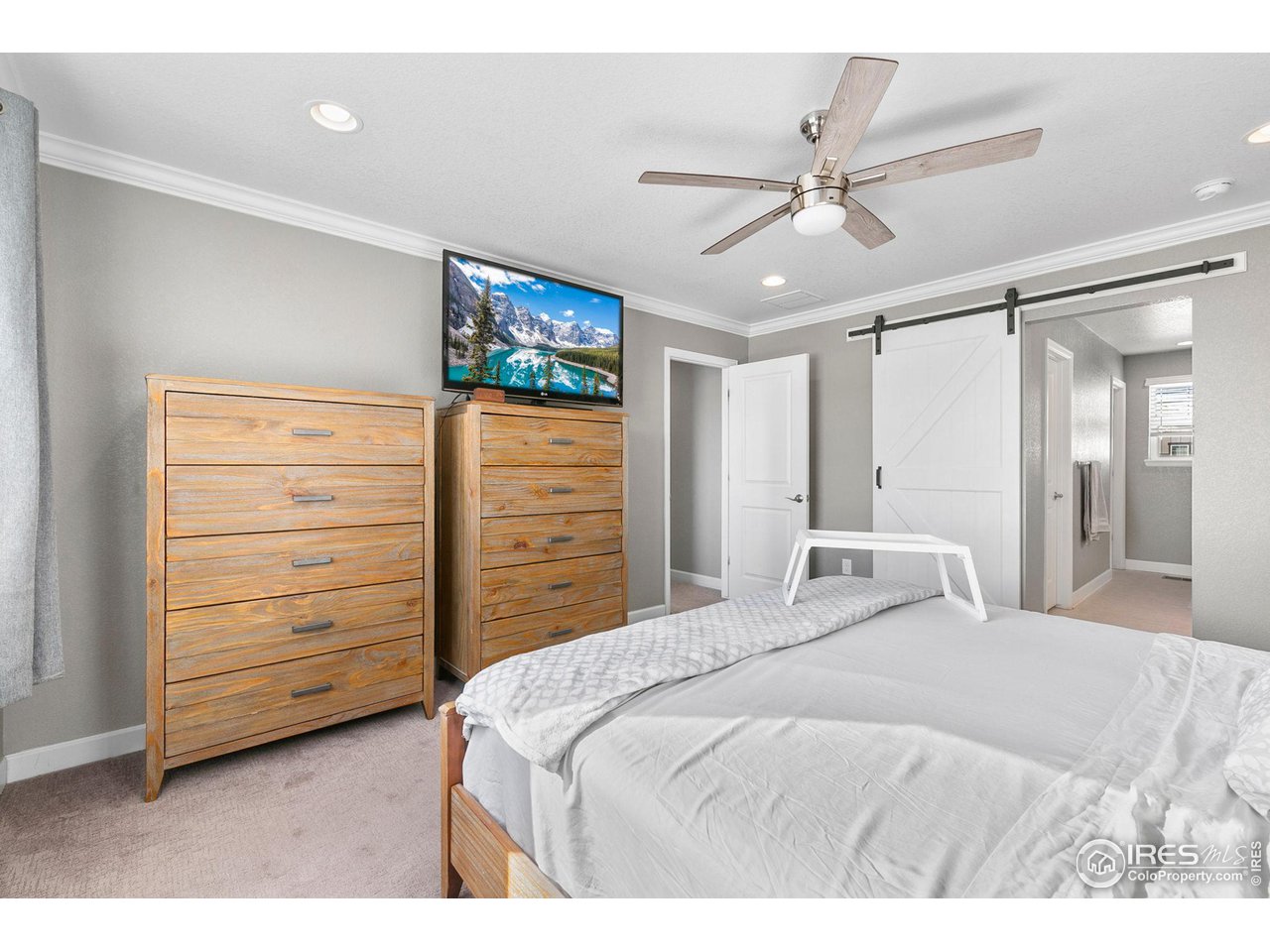 5231 Osbourne Drive Windsor, CO 80550 - Photo 12 of 20 a bedroom with a bed and a chandelier