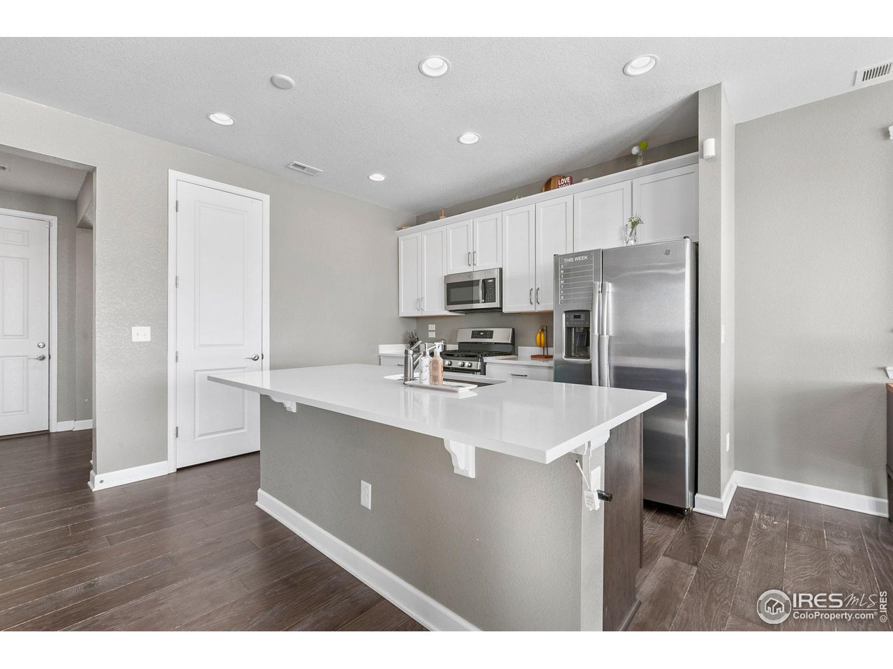 5231 Osbourne Drive Windsor, CO 80550 - Photo 6 of 20 a kitchen with kitchen island a sink stainless steel appliances and refrigerator