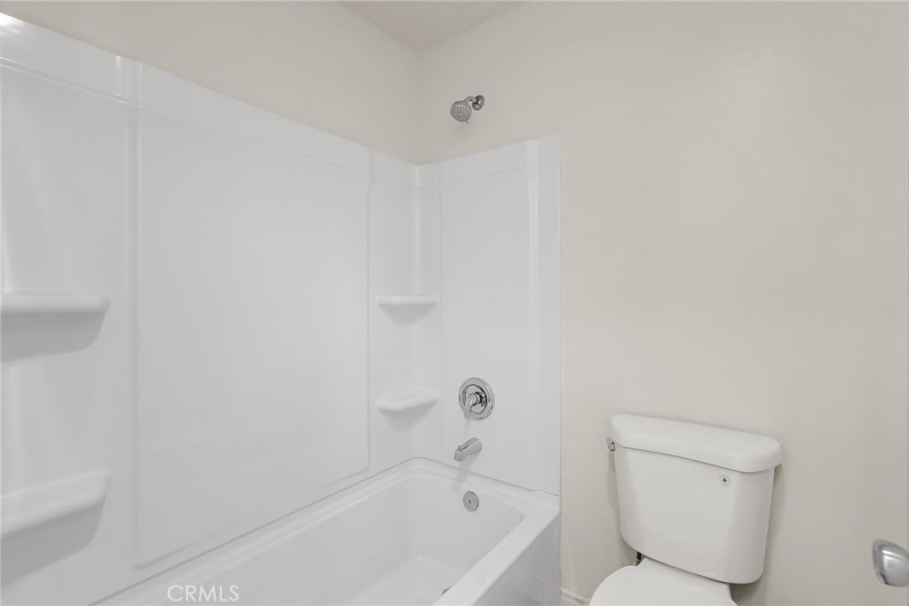 10668 Dabney Drive, Unit 125 San Diego, CA 92126 - Photo 21 of 27 a bathroom with a toilet and bathtub