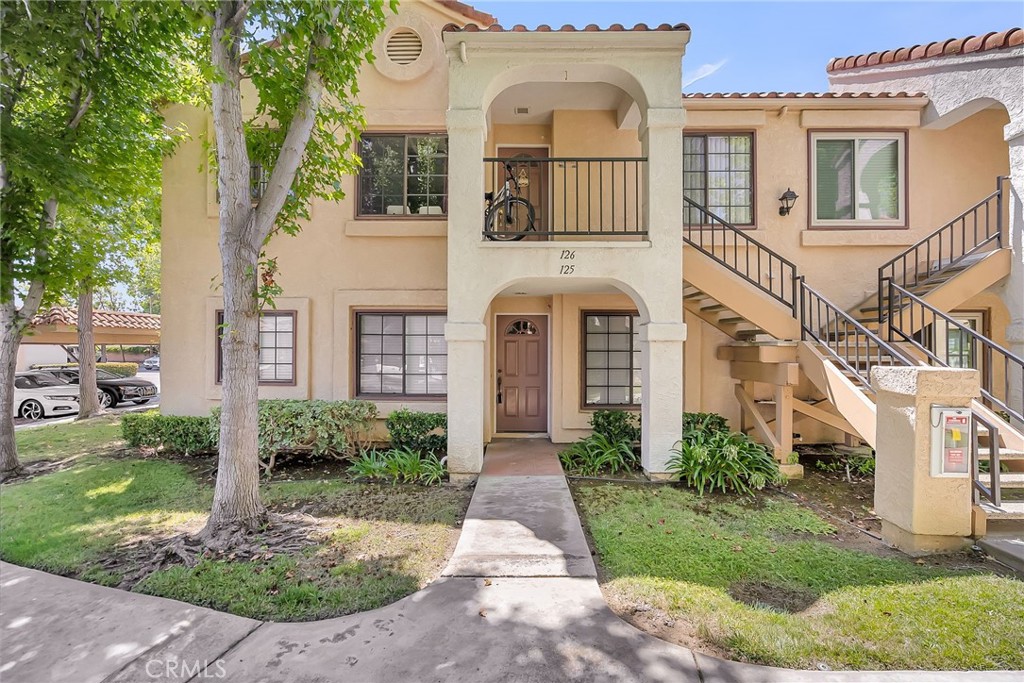 10668 Dabney Drive, Unit 125 San Diego, CA 92126 - Photo 3 of 27 front view of a brick house with a yard