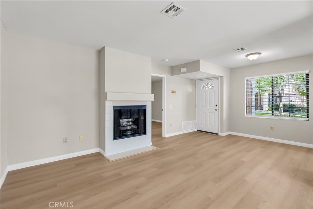 10668 Dabney Drive, Unit 125 San Diego, CA 92126 - Photo 6 of 27 an empty room with windows and fireplace