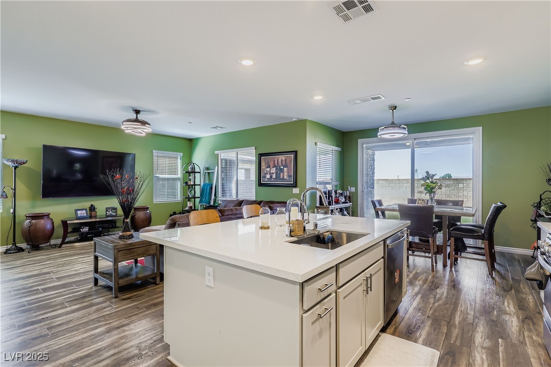 314 Robson Rdg Lane Henderson, NV 89015 - Photo 63 of 64 Kitchen with open floor plan, hanging light fixtures, light stone countertops, dark wood-style floors, and recessed lighting