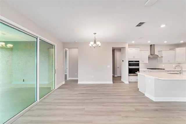 a view of kitchen with kitchen island wooden floor center island and stainless steel appliances