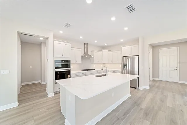 a large kitchen with a large counter top appliances and cabinets