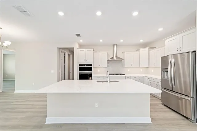 a large kitchen with kitchen island a sink stainless steel appliances and cabinets