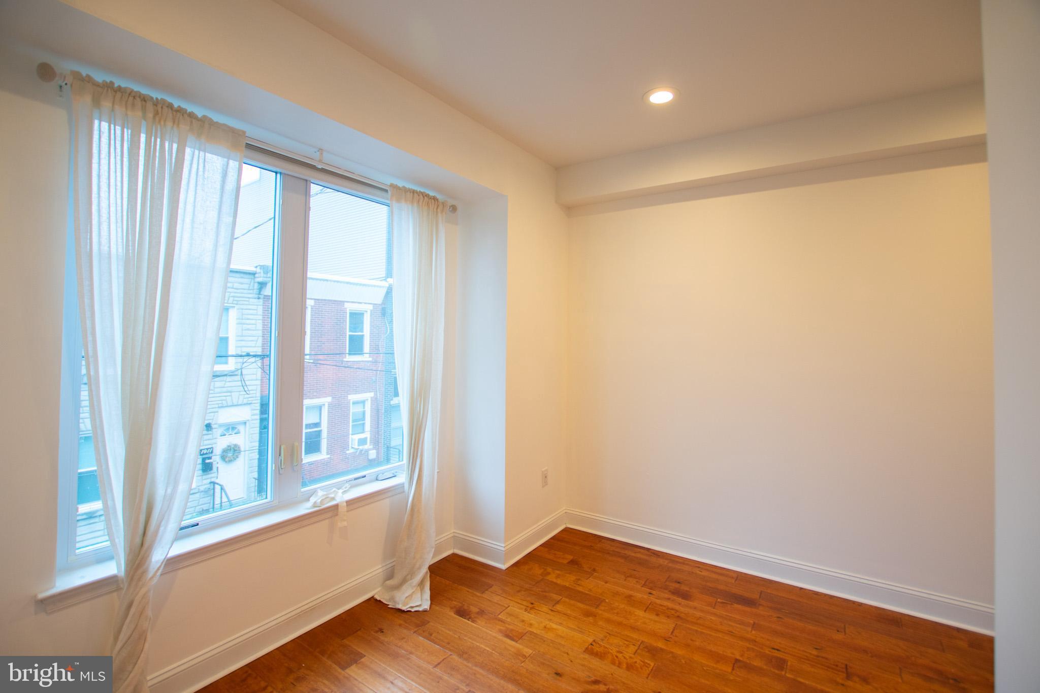1910 Fernon Street Philadelphia, PA 19145 - Photo 25 of 44 a view of an empty room with wooden floor and a window