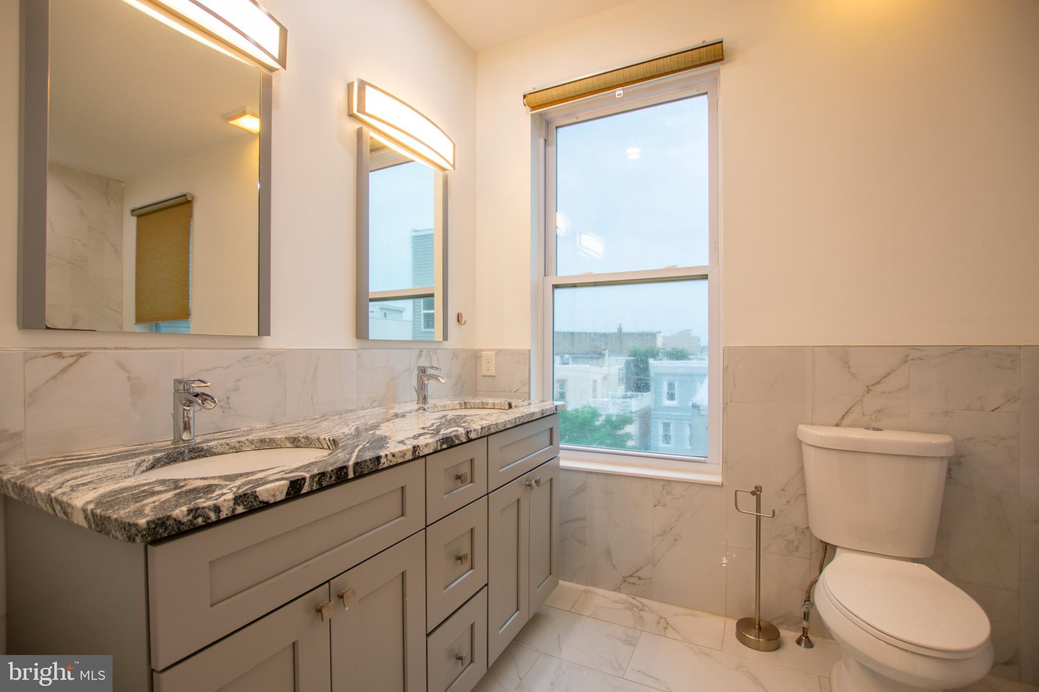 1910 Fernon Street Philadelphia, PA 19145 - Photo 37 of 44 a bathroom with a granite countertop toilet sink and mirror