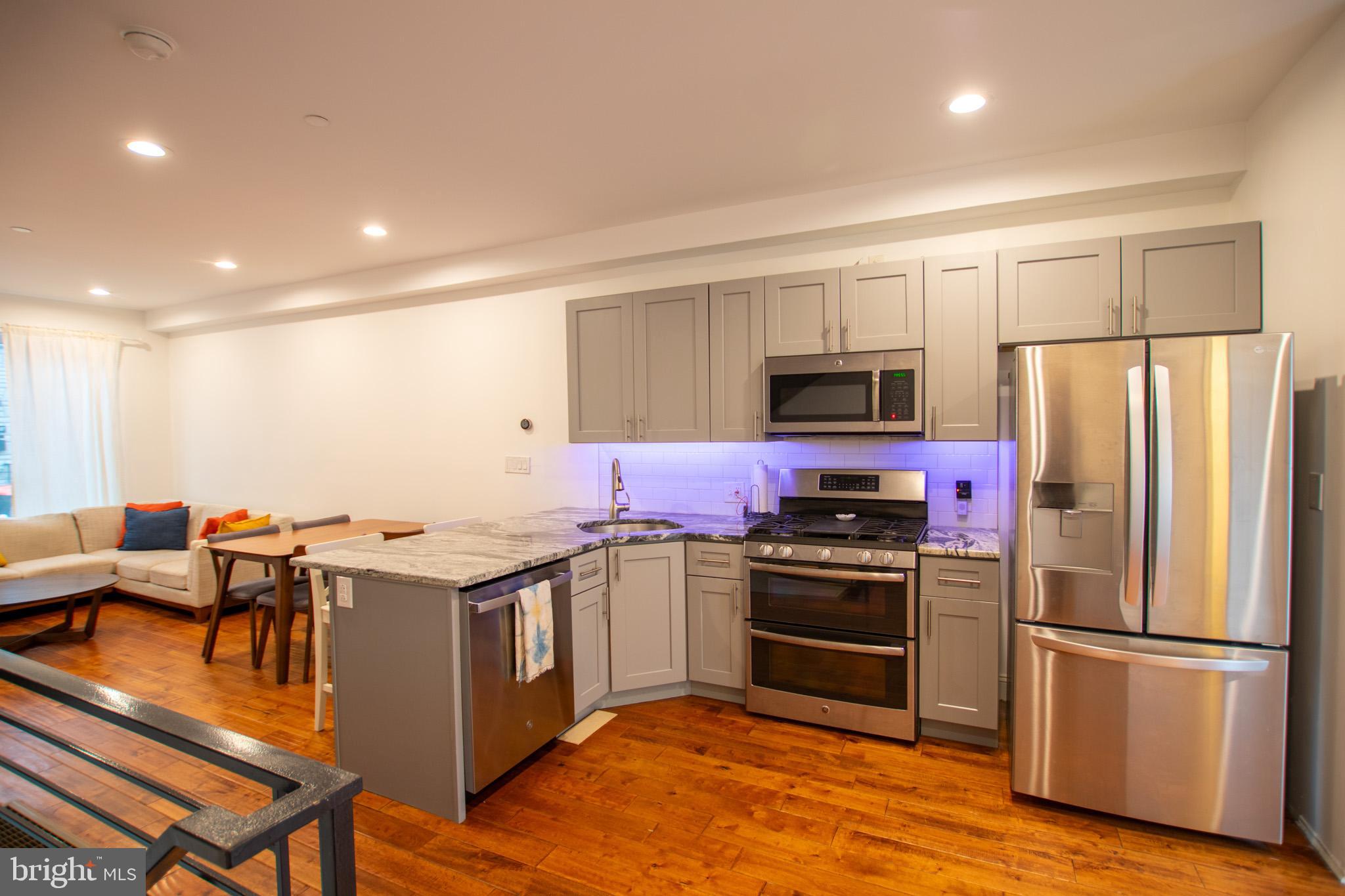 1910 Fernon Street Philadelphia, PA 19145 - Photo 7 of 44 a kitchen with stainless steel appliances a stove a sink a refrigerator and white cabinets