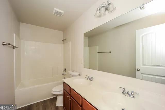 a bathroom with a tub sink toilet and a mirror