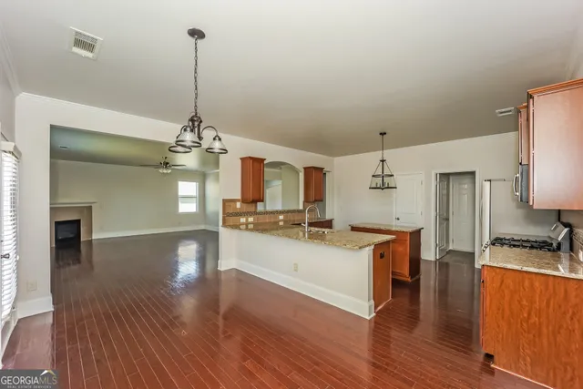 a view of a kitchen with cabinets stainless steel appliances and wooden floor