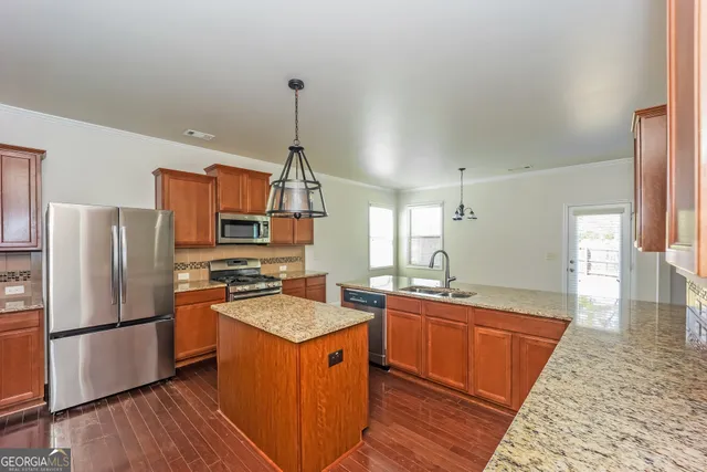 a kitchen with stainless steel appliances granite countertop a refrigerator a sink dishwasher a stove with wooden floor