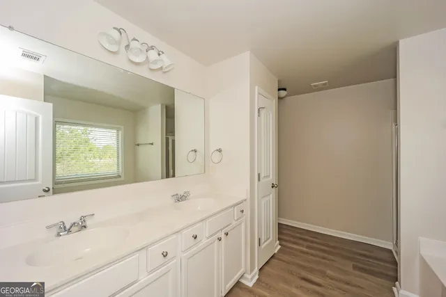a bathroom with a shower sink and mirror