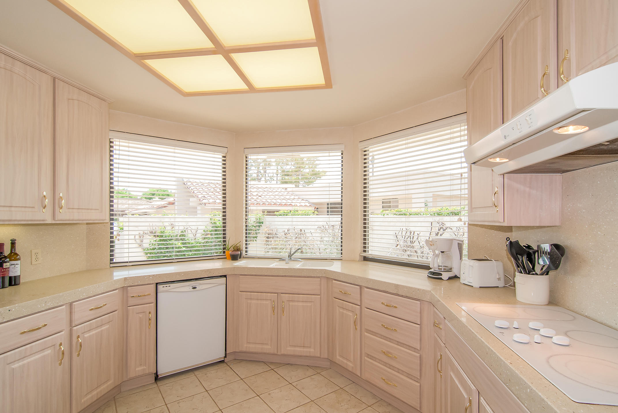 a kitchen with white cabinets and windows