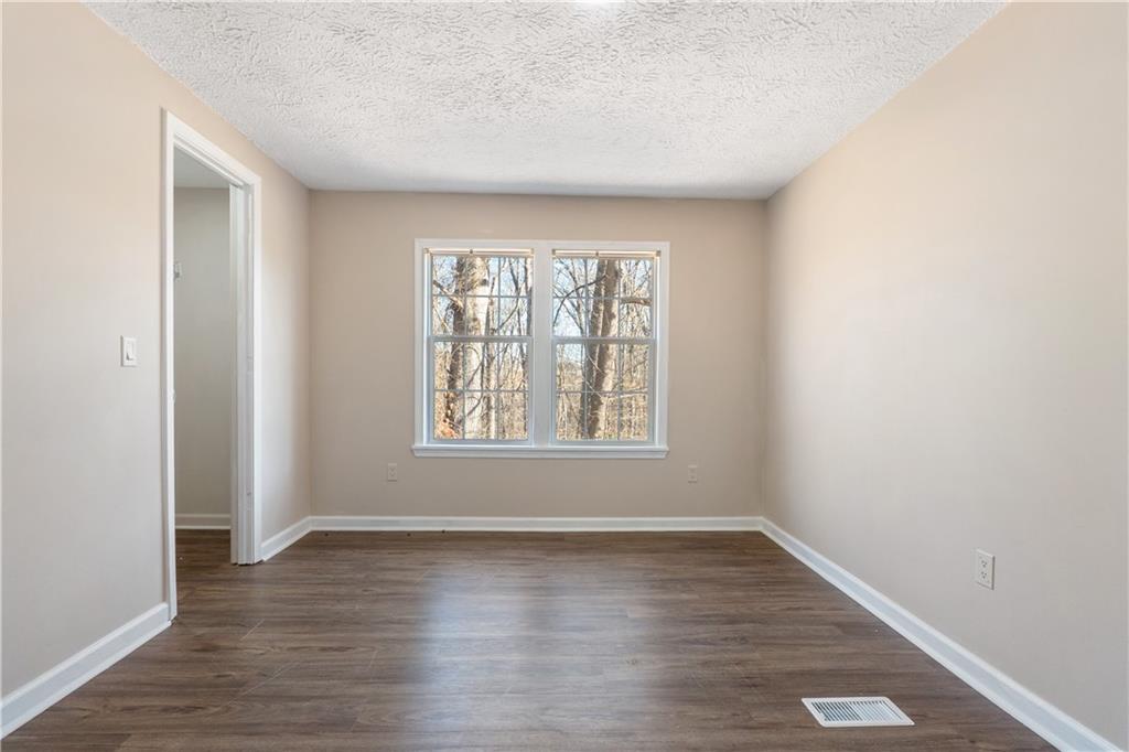 5498 Woodlin Road Lula, GA 30554 - Photo 11 of 40 an empty room with wooden floor and windows