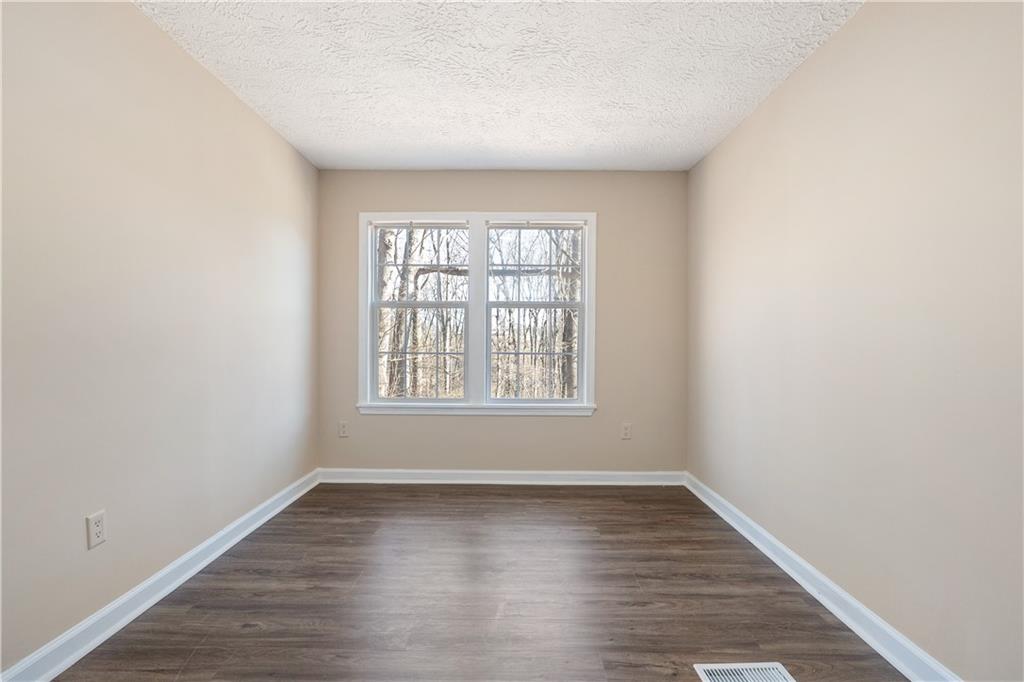 5498 Woodlin Road Lula, GA 30554 - Photo 12 of 40 an empty room with wooden floor and windows