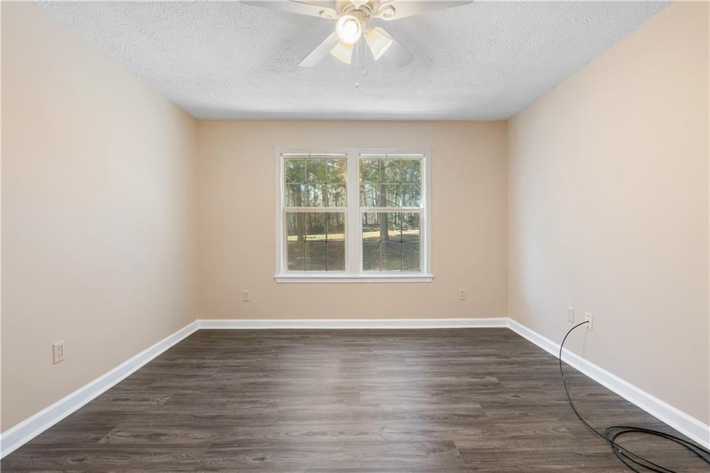 5498 Woodlin Road Lula, GA 30554 - Photo 13 of 40 an empty room with wooden floor and windows
