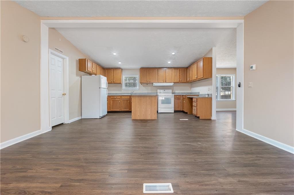 5498 Woodlin Road Lula, GA 30554 - Photo 3 of 40 a open kitchen with stainless steel appliances granite countertop a refrigerator and microwave