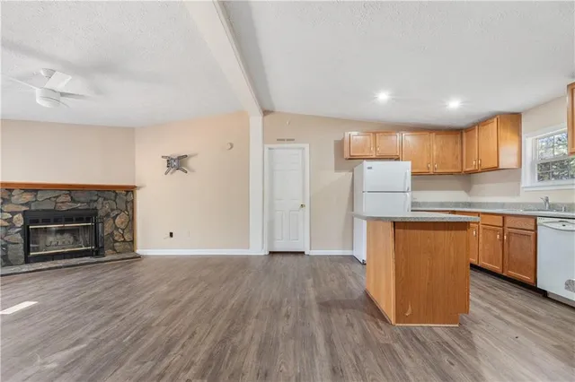 a kitchen with granite countertop wooden floors a fireplace and a window
