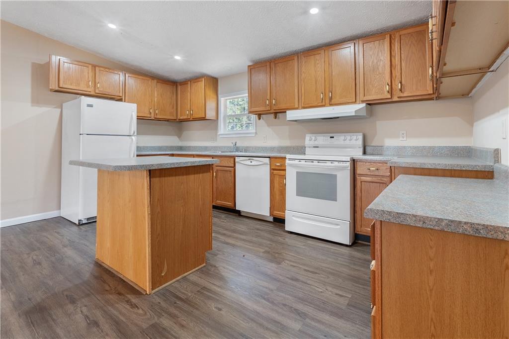 5498 Woodlin Road Lula, GA 30554 - Photo 5 of 40 a kitchen with a sink a stove a refrigerator and cabinets