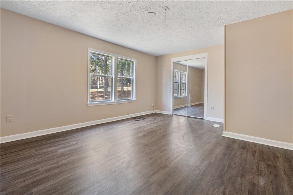 5498 Woodlin Road Lula, GA 30554 - Photo 9 of 40 an empty room with wooden floor and windows