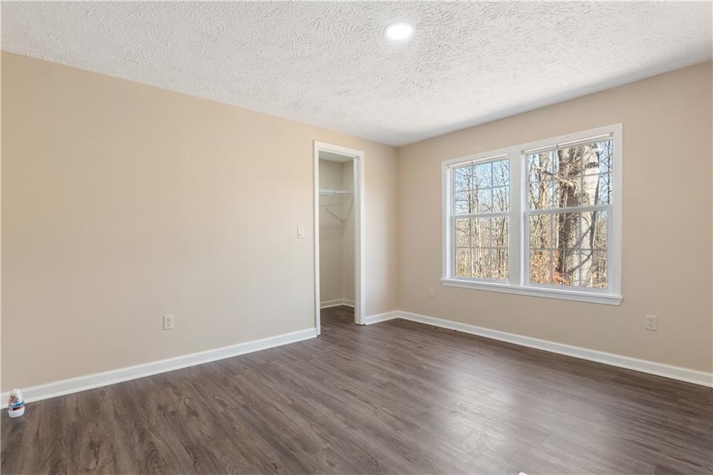 5498 Woodlin Road Lula, GA 30554 - Photo 10 of 40 an empty room with wooden floor and windows