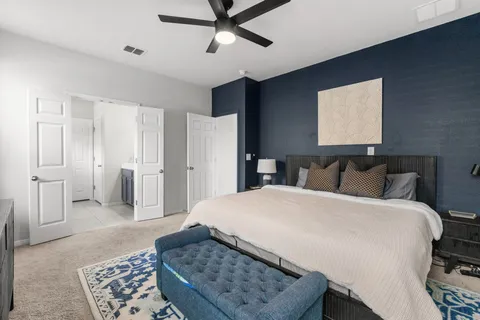 a spacious bedroom with a bed and cabinet