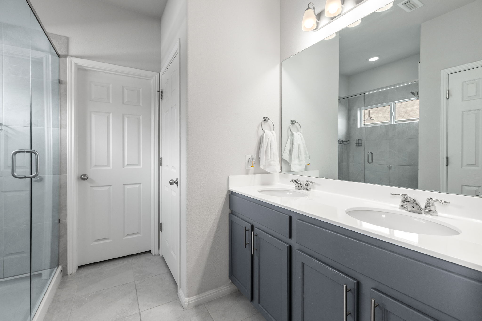 6402 Rafferty Lane Austin, TX 78747 - Photo 15 of 32 a bathroom with a double vanity sink mirror and shower
