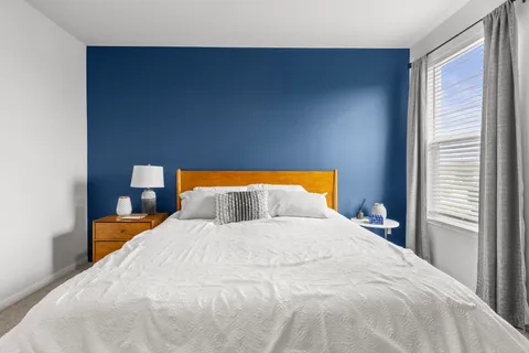 a large bed sitting in a bedroom next to a window