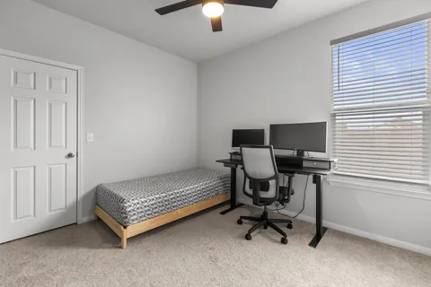 a view of a workspace with furniture and a window