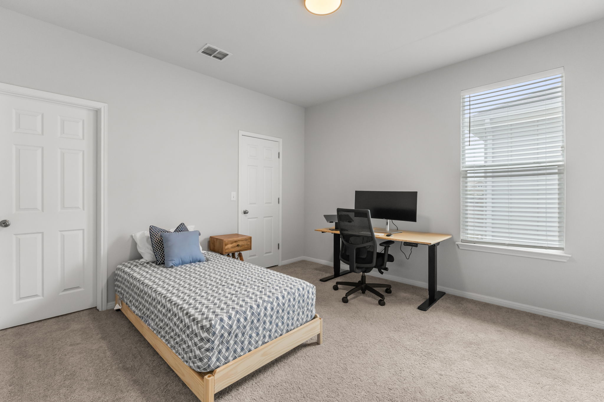 6402 Rafferty Lane Austin, TX 78747 - Photo 27 of 32 a bedroom with a bed and a computer on the desk