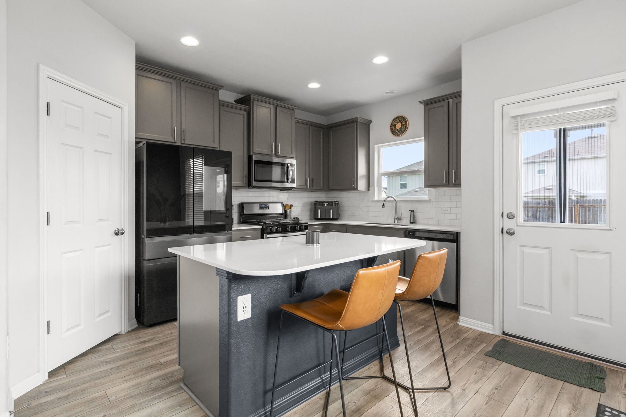 6402 Rafferty Lane Austin, TX 78747 - Photo 5 of 32 a kitchen with stainless steel appliances granite countertop a sink a stove a refrigerator and island with wooden floor