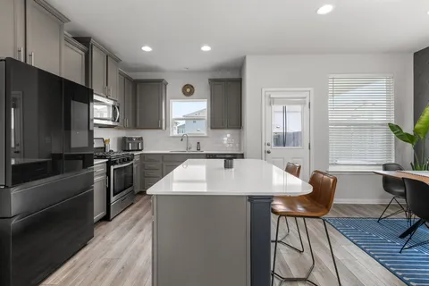 a kitchen with stainless steel appliances granite countertop a sink stove refrigerator and cabinets