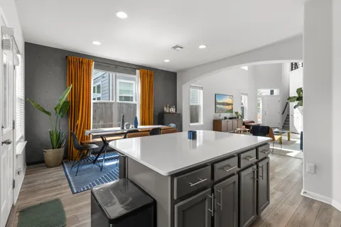 a living room with hard wood floors and a kitchen