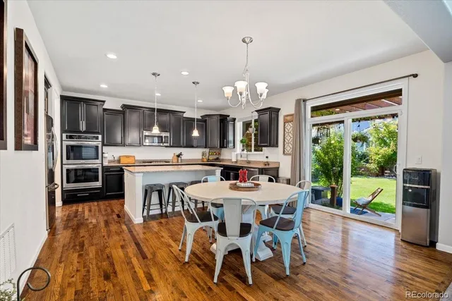 a view of a dining room and livingroom with furniture wooden floor a chandelier