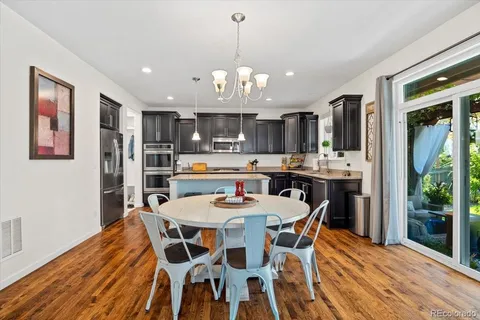 a dining room with stainless steel appliances kitchen island granite countertop a dining table chairs and a oven
