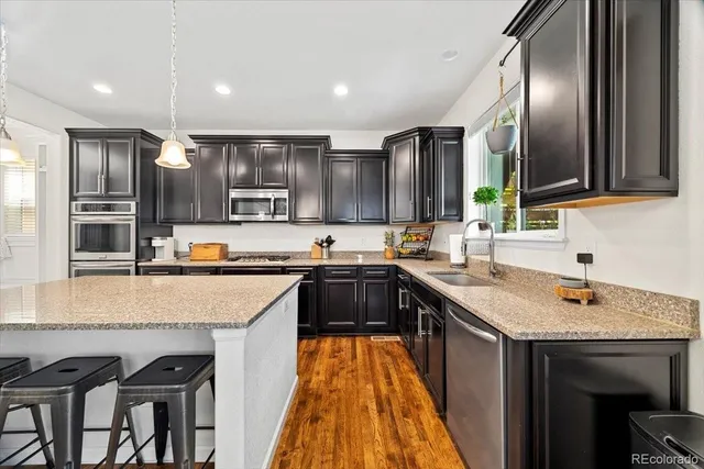 a kitchen with stainless steel appliances granite countertop a sink stove and refrigerator