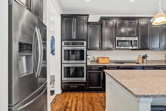 a kitchen with stainless steel appliances granite countertop a refrigerator and a stove top oven