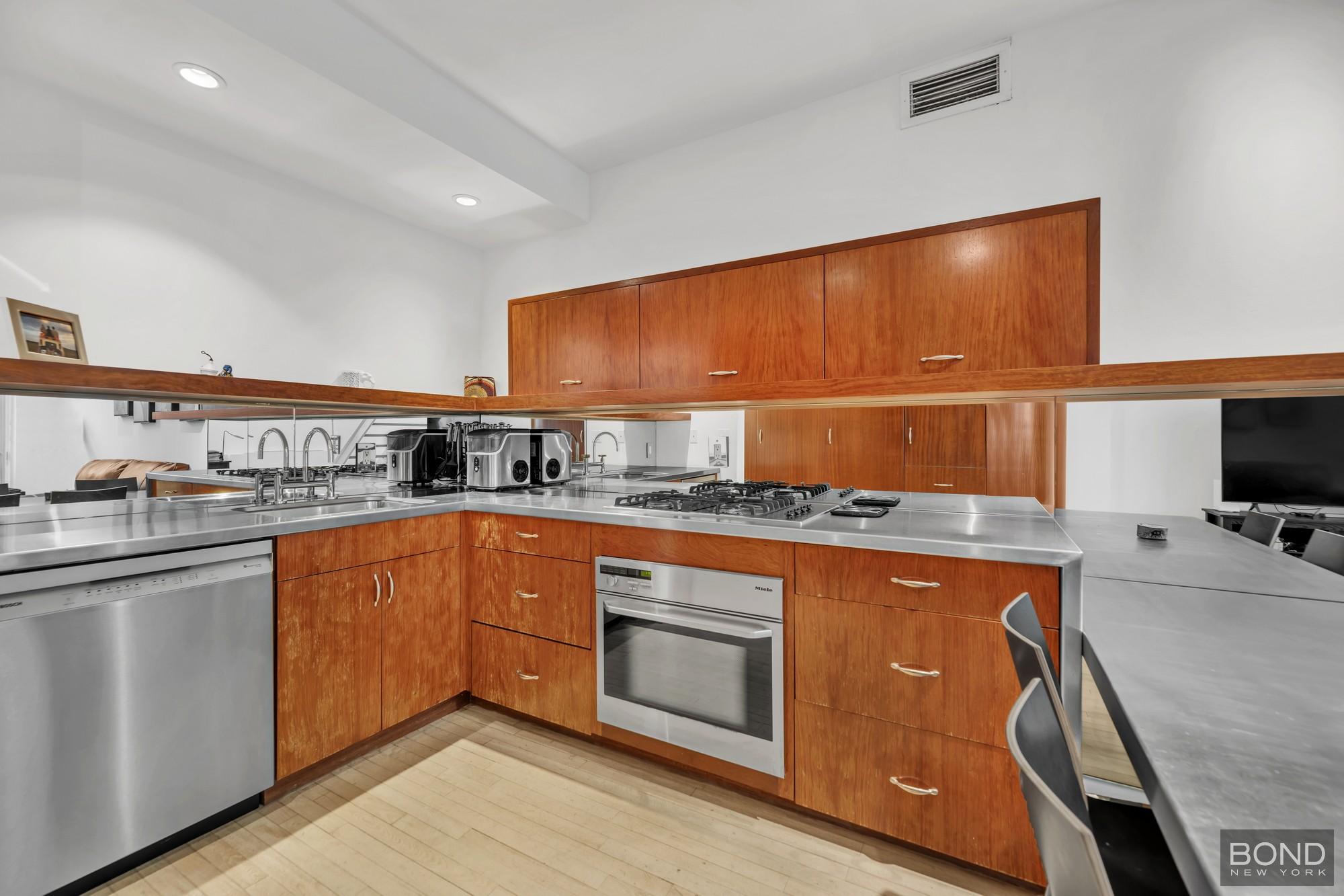 32 East 76th Street, Unit 502602 Manhattan, NY 10021 - Photo 2 of 8 a kitchen with stainless steel appliances granite countertop a stove and a sink